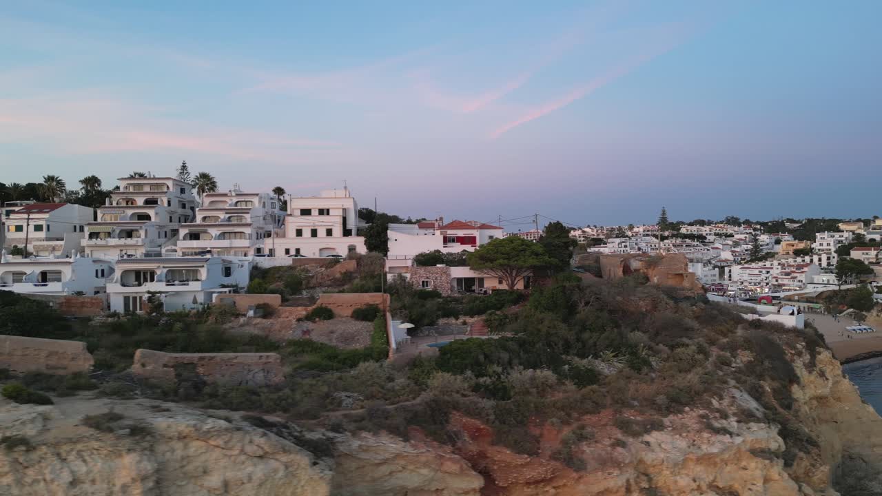 드론은 카르보에이로 (carvoeiro), 알가르베 (algarve), 포르투갈 (portugal) 마을에서 황금 시간 해가 지는 동안 가장 높은 절벽의 높이에서 왼쪽에서 오른쪽으로 이동합니다.