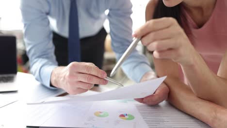 businessman and businesswoman is studying statistics in business graphs