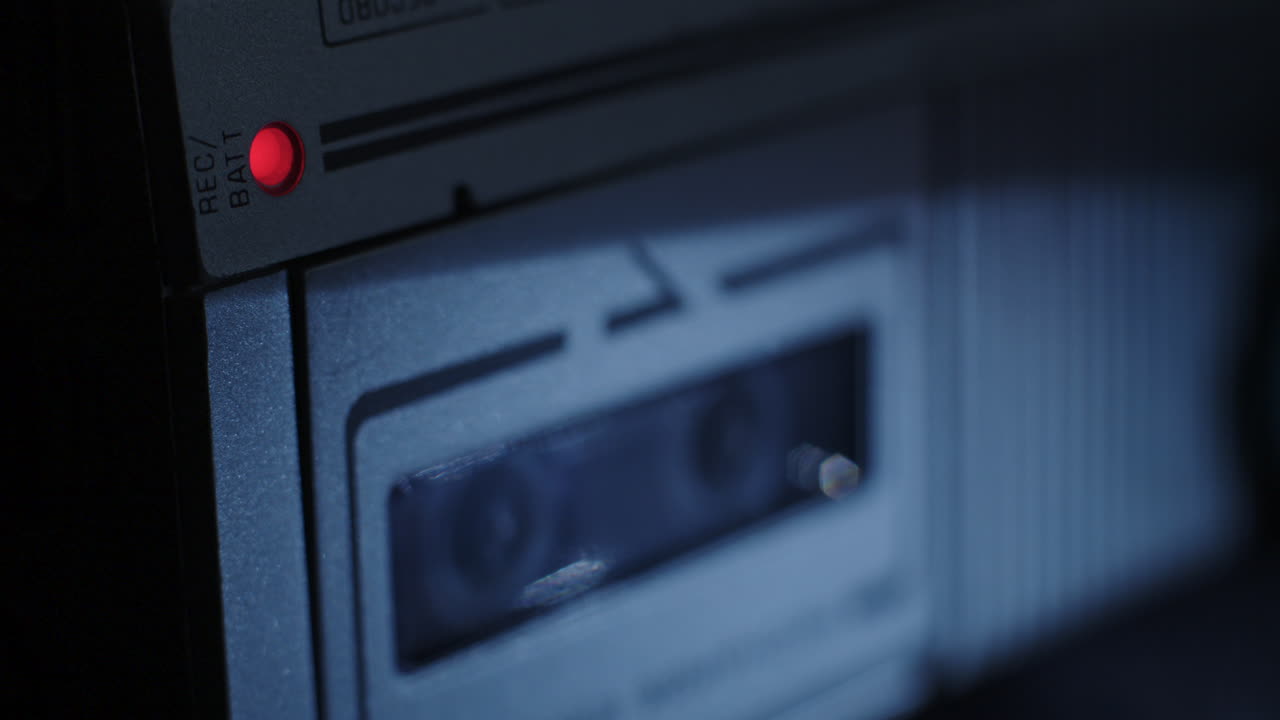 luz roja de registro de microcassette iluminada con carretes girando en segundo plano