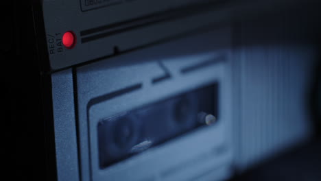 luz roja de registro de microcassette iluminada con carretes girando en segundo plano
