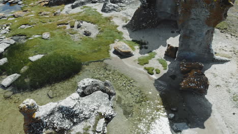 aerial view of rock formations on land and in water at sea coast