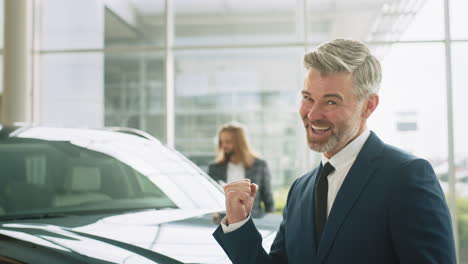 happy car dealer celebrating a successful sale