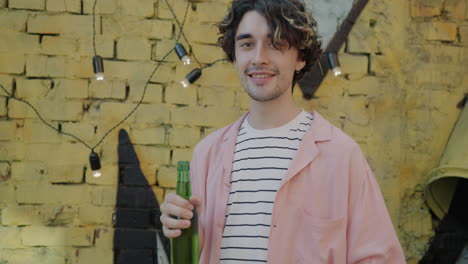 Man holding a beer bottle outdoors