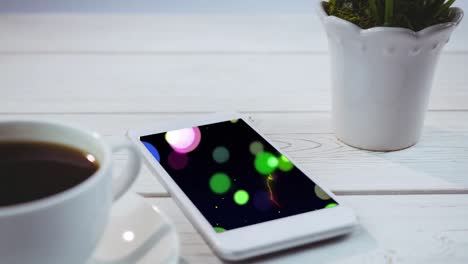 Animation-of-spots-of-light-on-smartphone-screen-on-desk