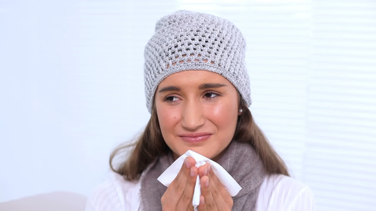 молодая женщина выдыхает нос салфеткой.