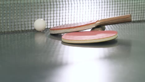 two red ping pong rackets on a dark tennis table. sports equipment for the match in ping pong