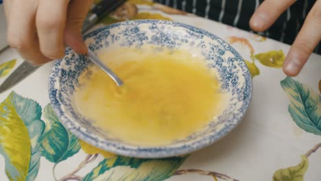 mixing egg yolk inside a plate with water