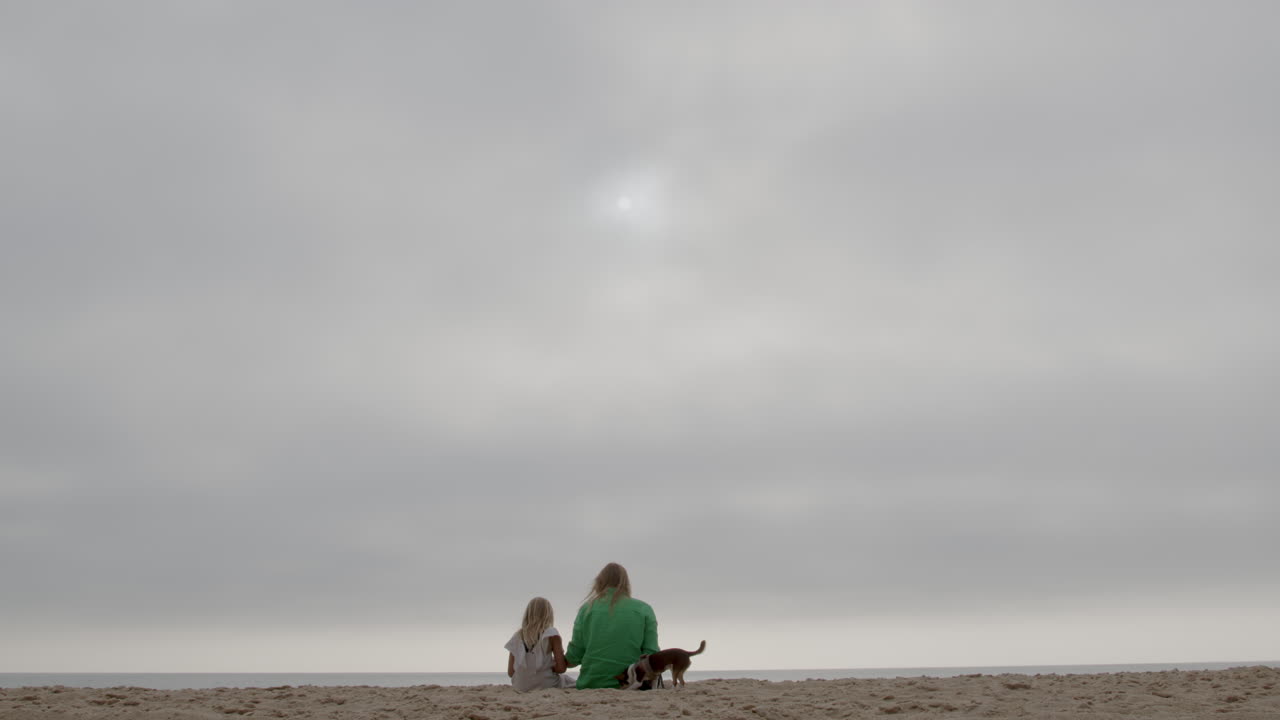 해변 에서 구름 이 가득 한 날 을 즐기는 가족