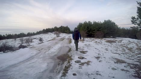 Man-walking-away-in-a-frost-path