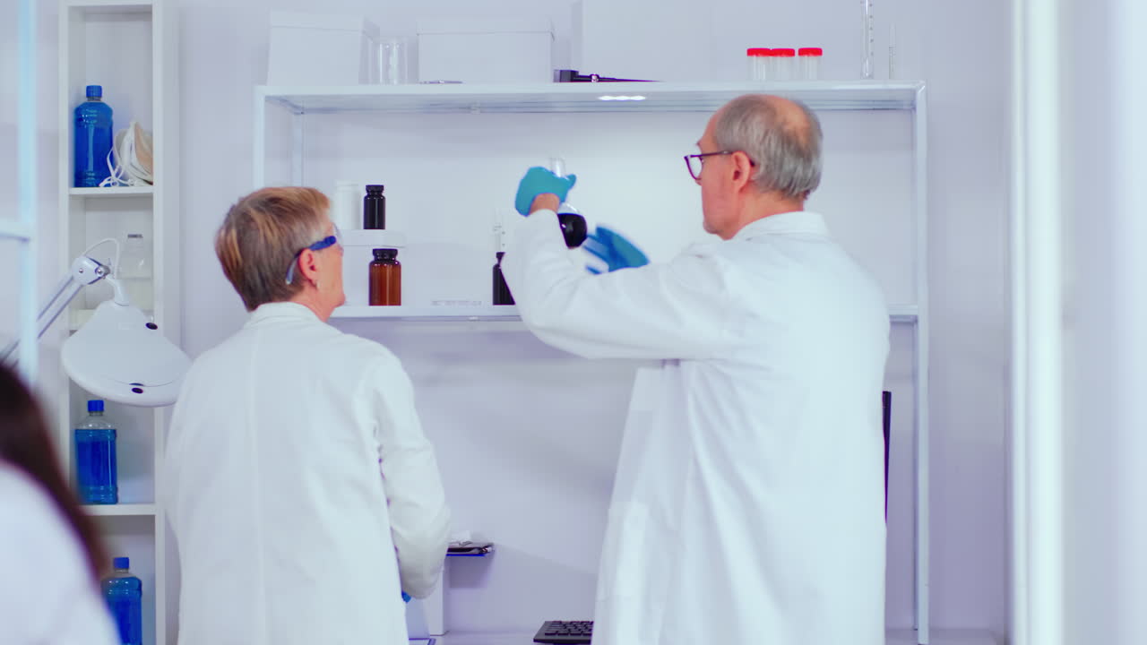 Elderly biochemists working in modern laboratory