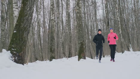 Man-and-woman-run-in-the-park-in-winter-in-slow-motion