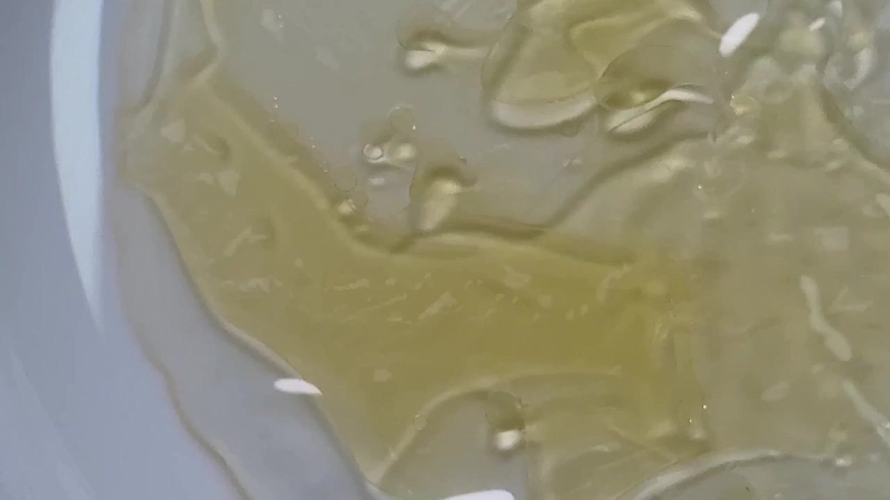 泡が浮かぶ粘性のある黄色い液体の抽象的なマクロ撮影