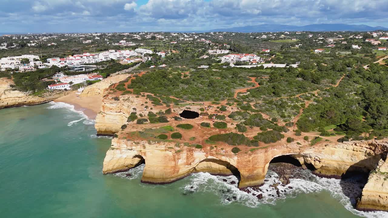 Drone captures Benagil Cave with turquoise ocean and cliffs