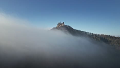 the drone continues its journey, moving further into the misty clouds above hohenzollern castle, blending the breathtaking german countryside with a mysterious, dreamlike atmosphere.