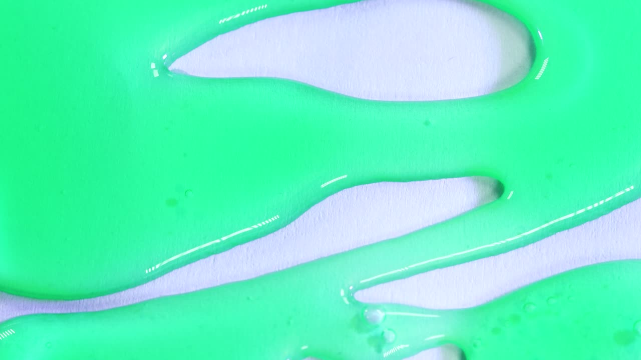 흰색 표면 배경에 떨어지는 녹색 반투명 밀도 물질