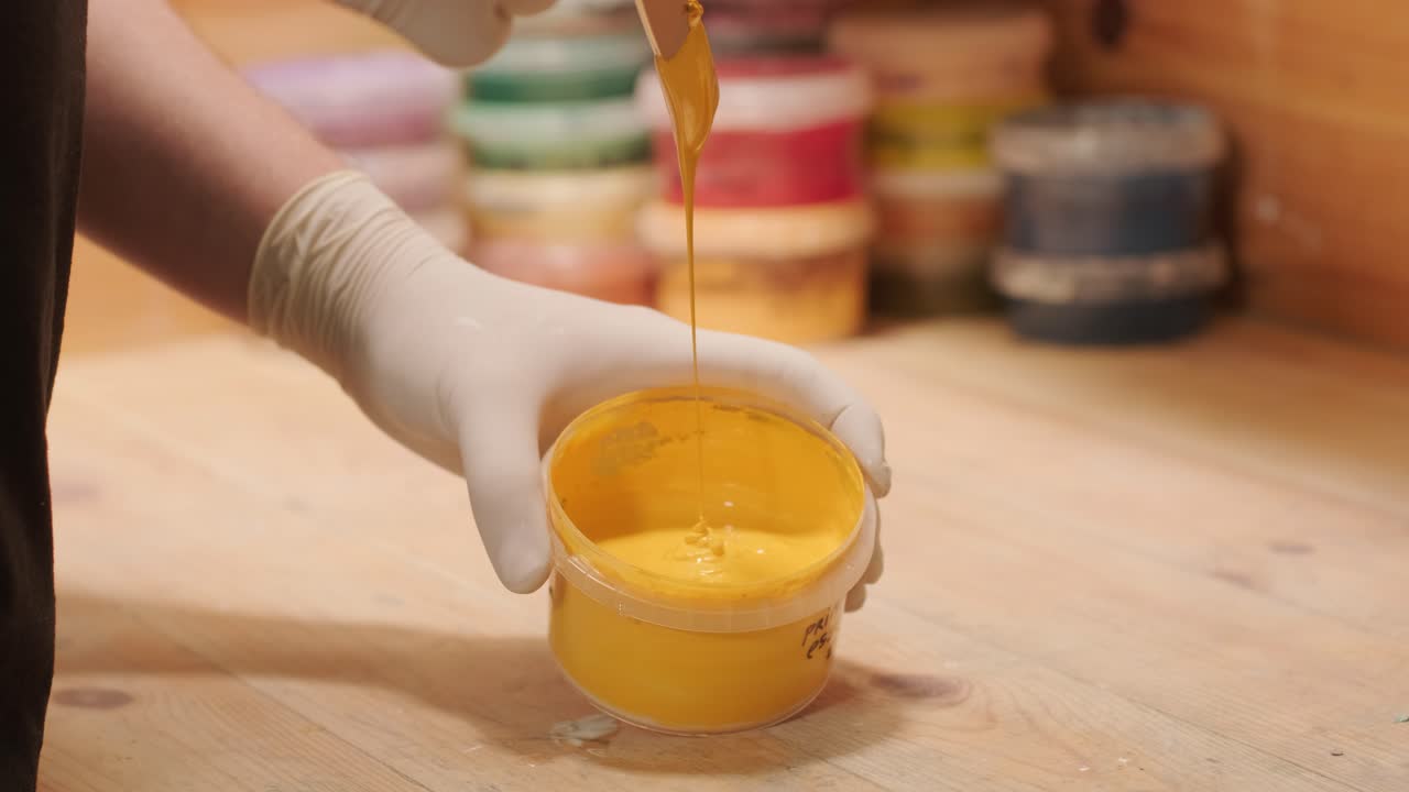 un trabajador amasa la pintura para pintar las paredes