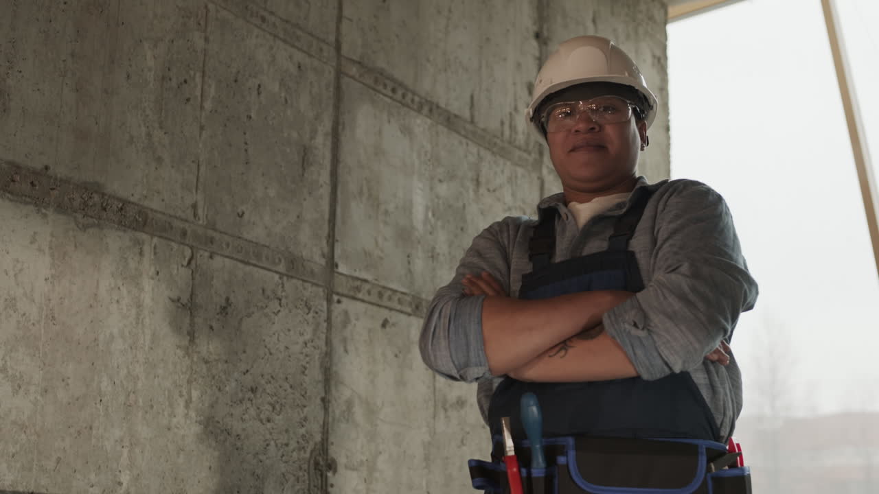 trabajador de la construcción biracial con casco posando