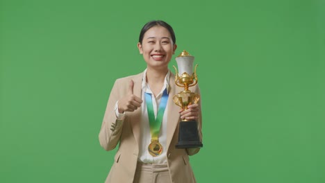 mujer sosteniendo el trofeo y dando pulgares hacia arriba