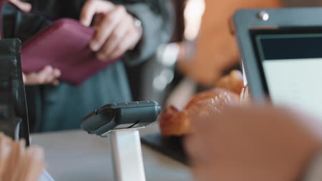 close up customer paying using credit card contactless payment spending money in cafe with digital transaction service