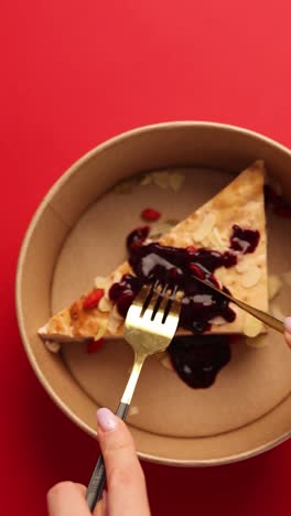 woman eating a slice of healthy vegan cake with berries and almonds