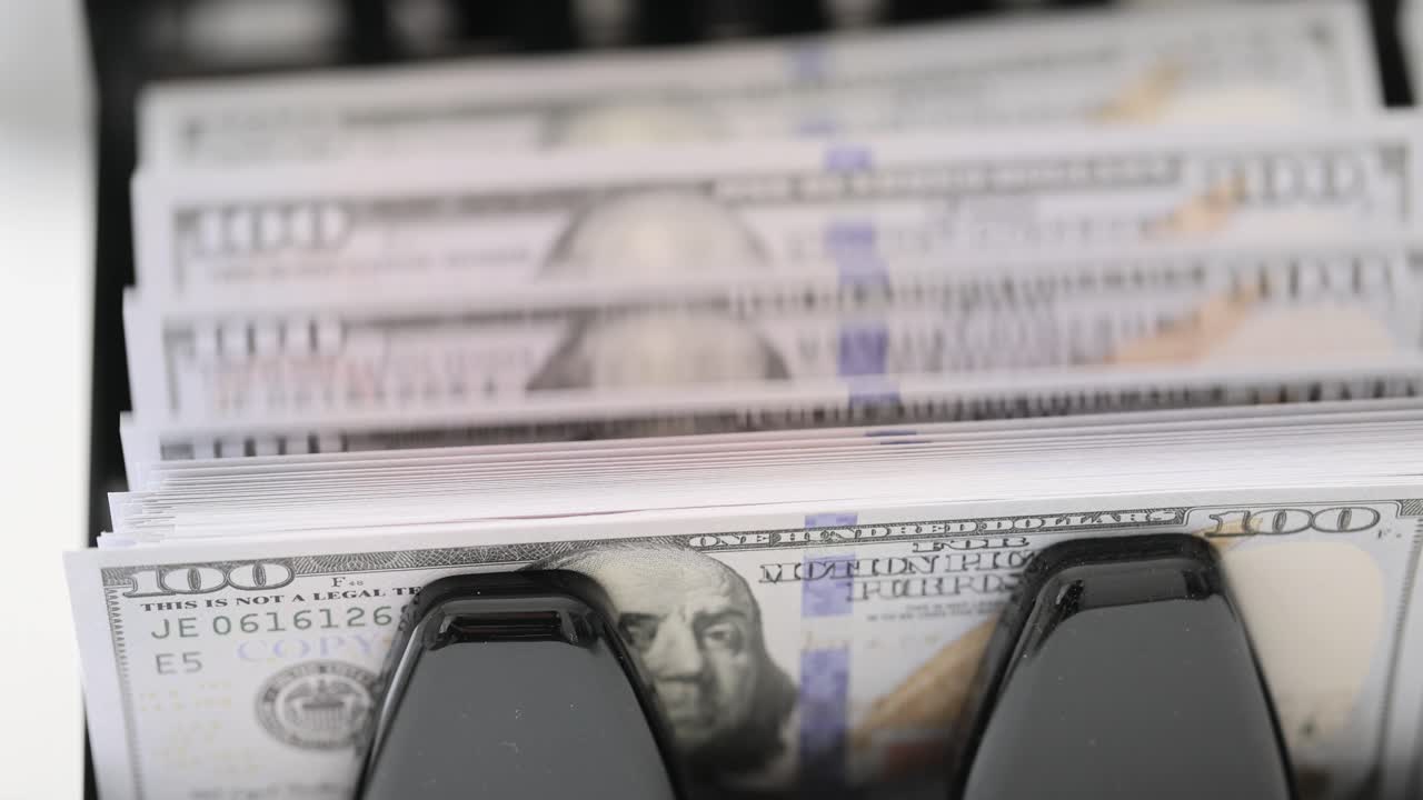 US Hundred Dollar Bills Being Counted by a Machine