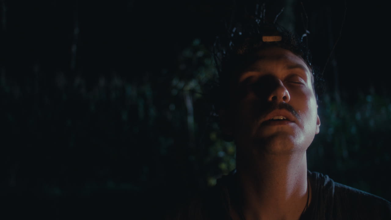 Man with Branch Headpiece in Dark Forest at Night