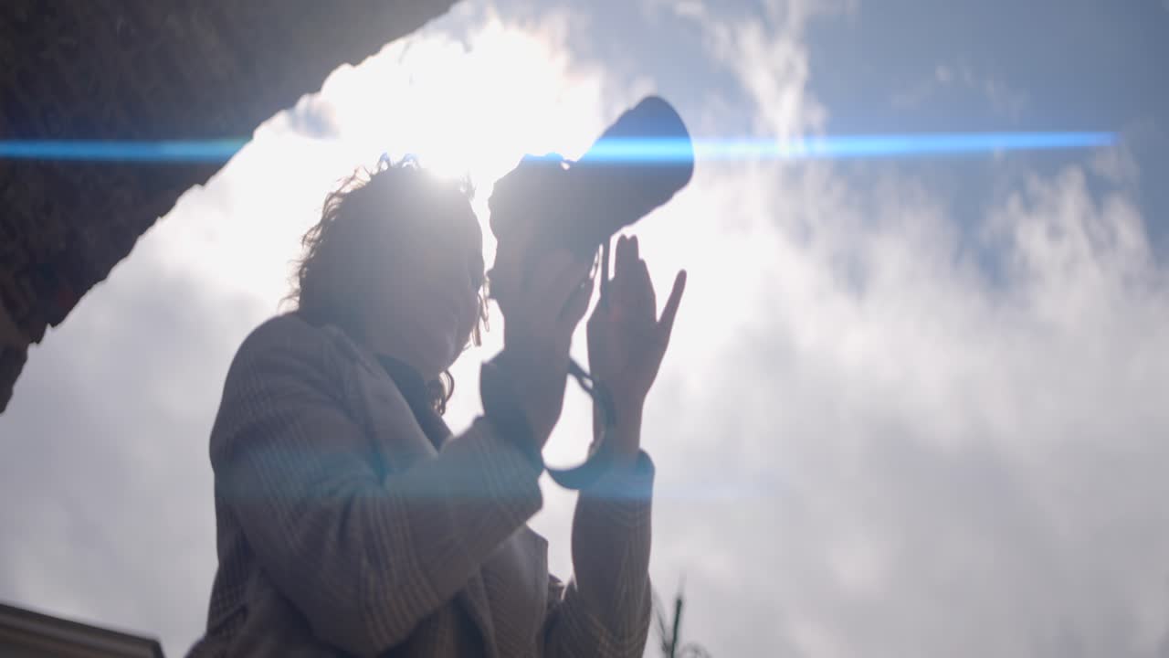 空を写真に撮っている女性