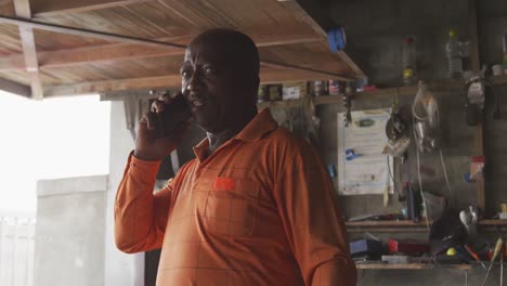 hombre africano hablando por teléfono en el trabajo