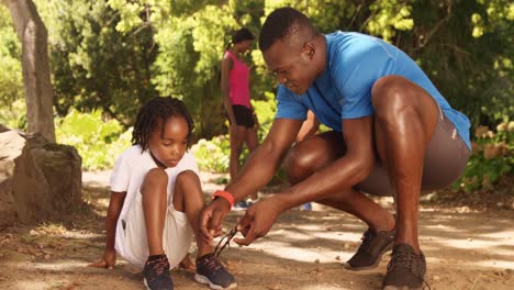 father is doing his son shoelaces