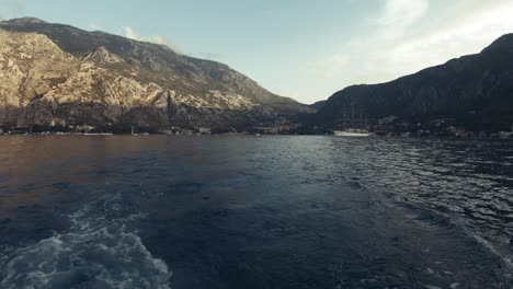 Statische-Pov-aufnahme,-Von-Einem-Boot,-Das-Die-Stadt-Kotor-Verlässt,-Umgeben-Von-Bergen,-Boote-Auf-Der-Adria,-An-Einem-Sonnigen-Tag,-In-Montenegro