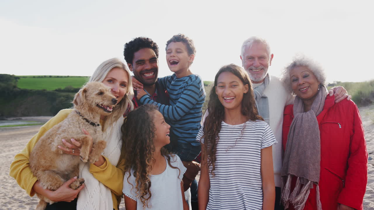retrato de una familia activa de varias generaciones con un perro mascota en vacaciones de playa de invierno