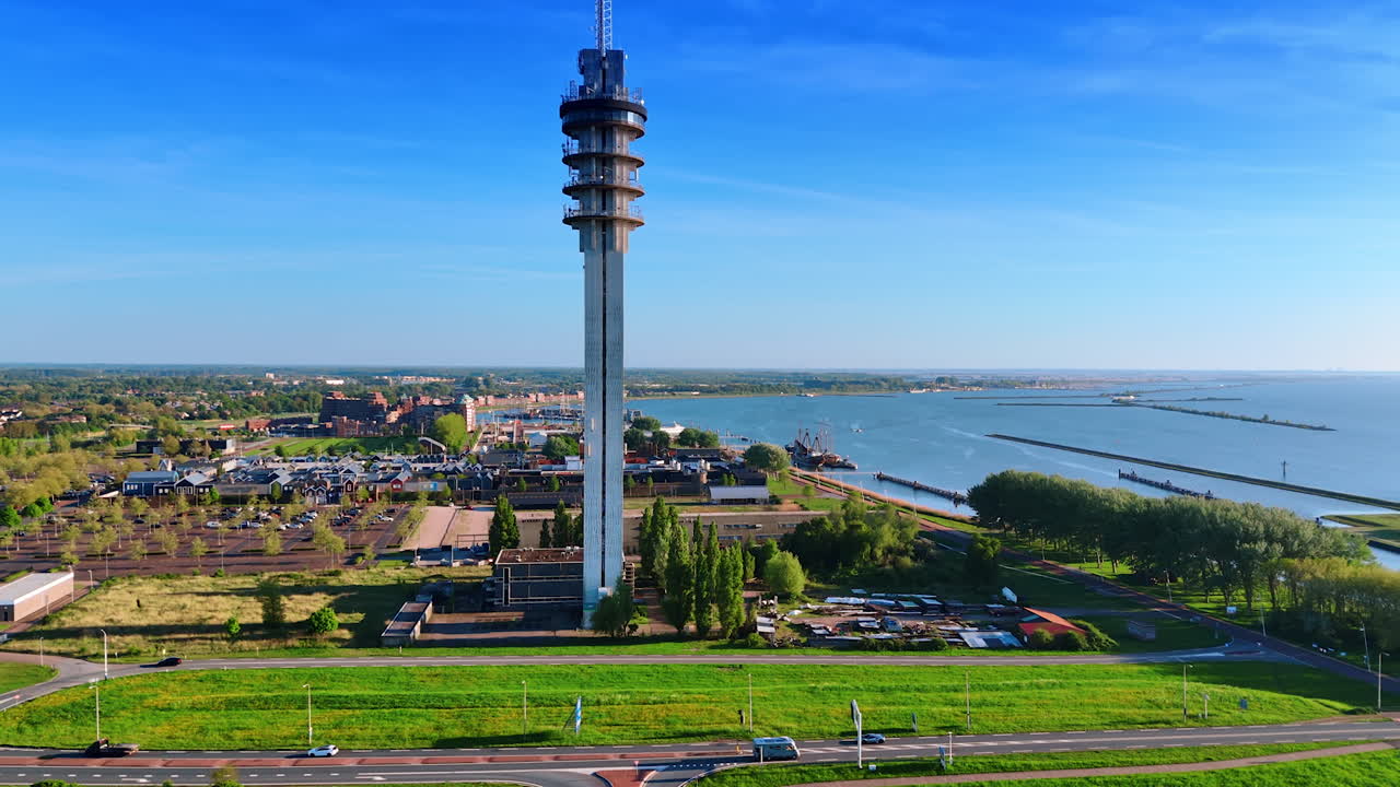 Telecom tower soaring above the low-rise cityscape of Lelystad, the Netherlands. Vast panorama of the city with beautiful marina. Aerial view.