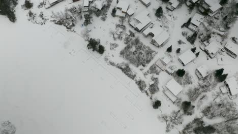 inclinación aérea sobre un tranquilo pueblo cubierto de nieve en el norte de canadá