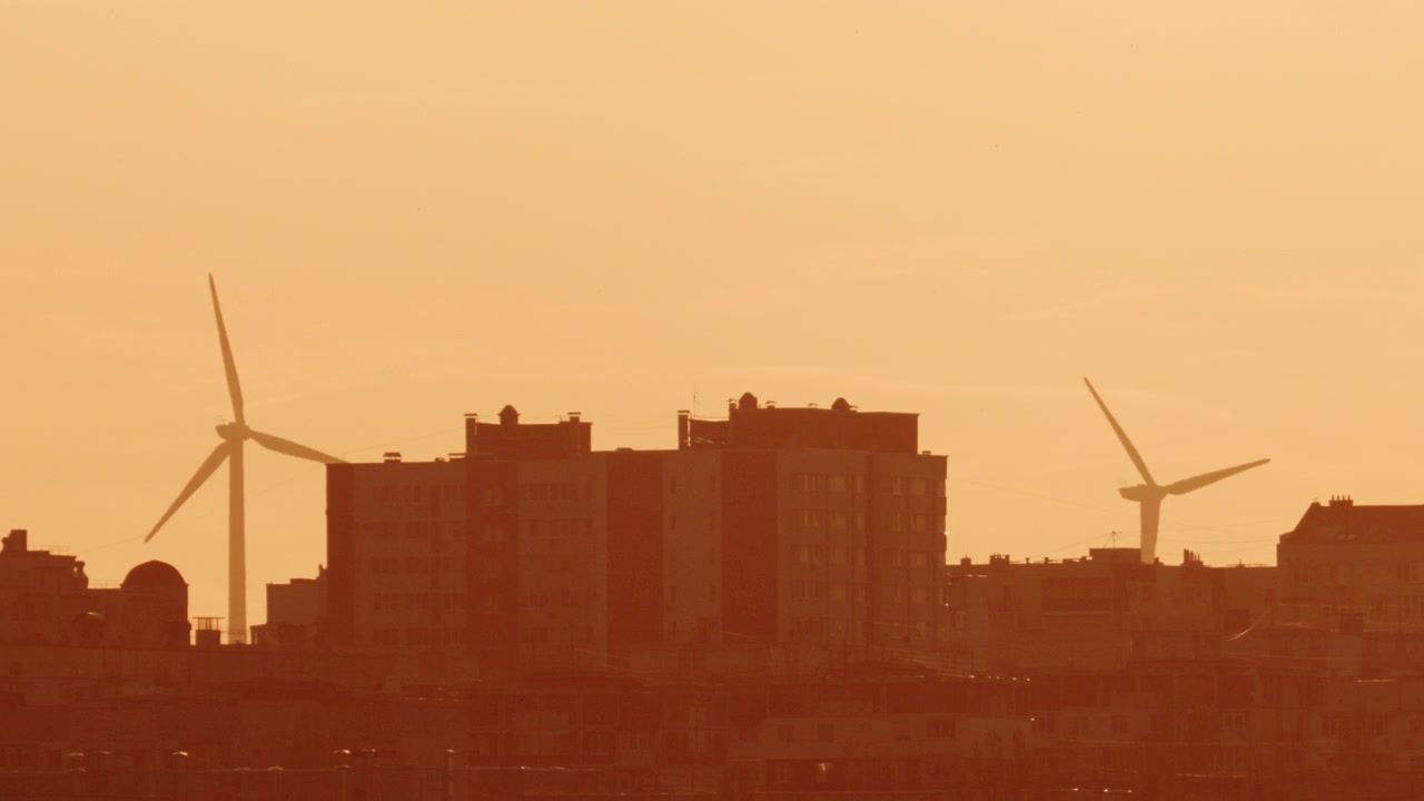 Toma cinematográfica de un sol brillante parcialmente difuminado por nubes dispersas, resplandeciendo en tonos naranja intenso y ámbar.