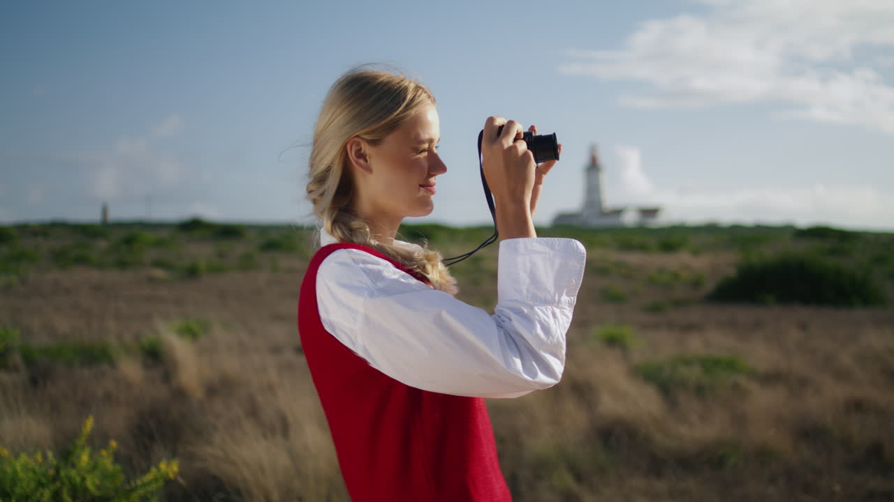 fotógrafo positivo disparando a la naturaleza de cerca. verticalmente mujer mirando hacia el sol