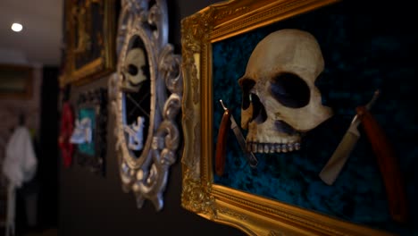 tattoo studio interior walls decorated with framed skulls with barber blades and tattooing needles. slow motion