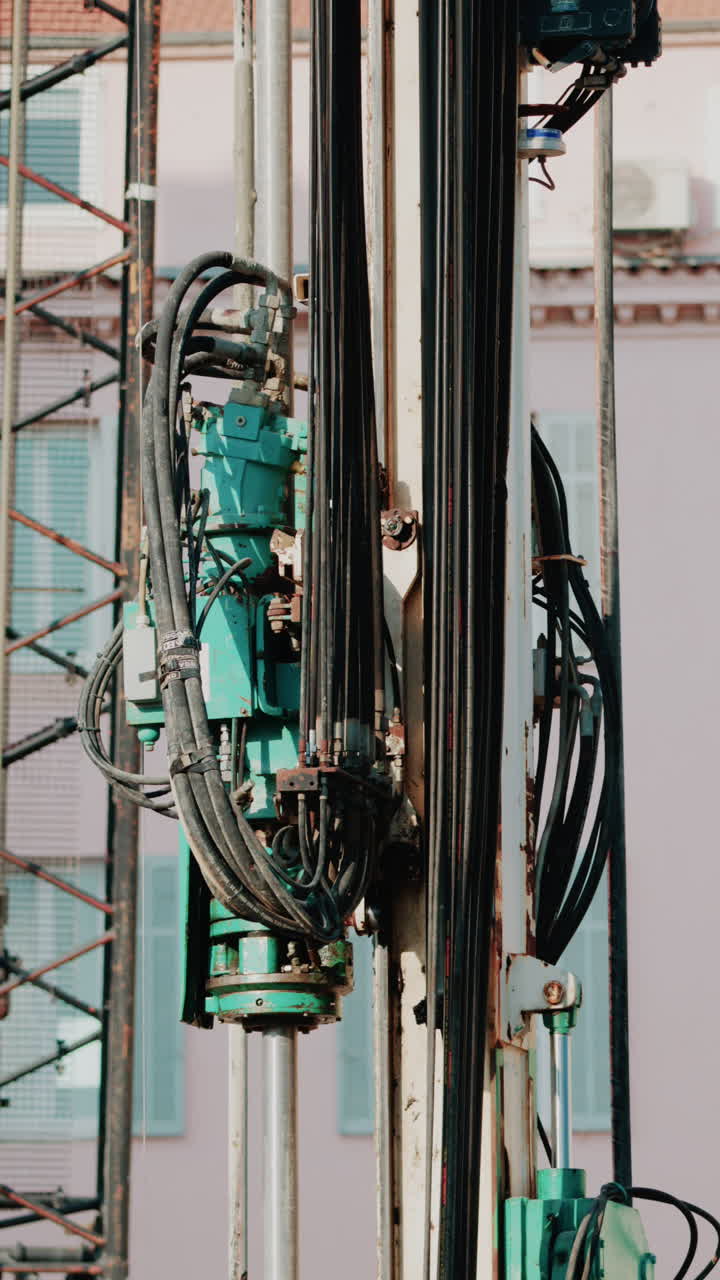 Close up of industrial drilling equipment with hydraulic cables and metal framework
