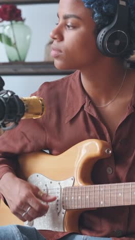 musician plays guitar while lost in melodies during a creative session