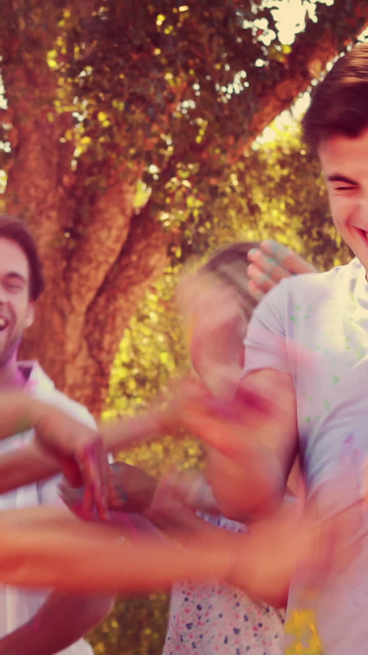 amigos felices arrojando pintura en polvo en el parque