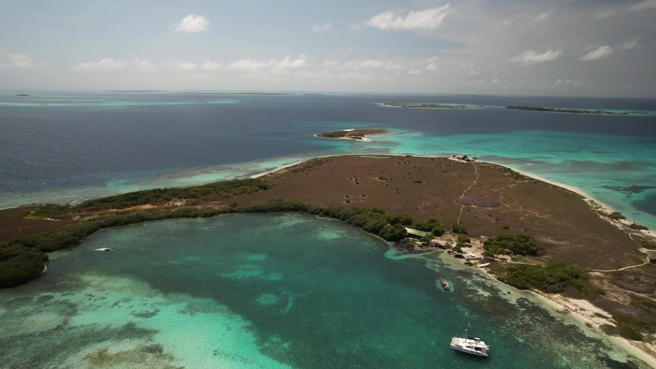 Isola di Franisky con acque turchesi e coste sabbiose in una giornata di sole, vista aerea.