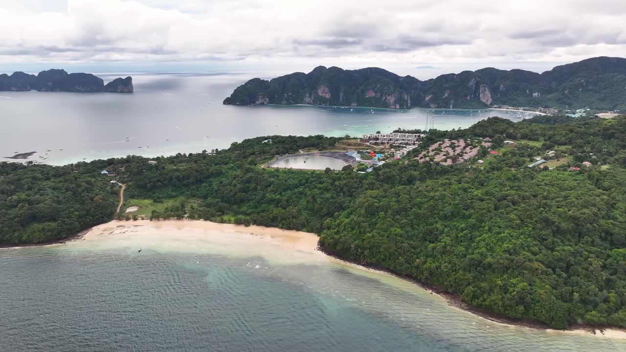 Sandy beach and tropical surroundings. Loh Moo Dee, Koh Phi Phi Islands, Thailand. Cloudy drone