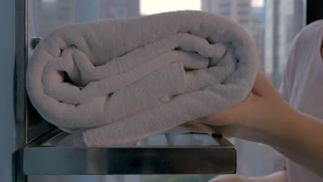 housekeeper placing bath towels in hotel bathroom