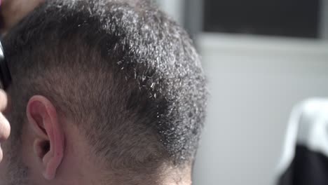 primer plano de peluquero de moda corta el pelo del hombre en la barbería