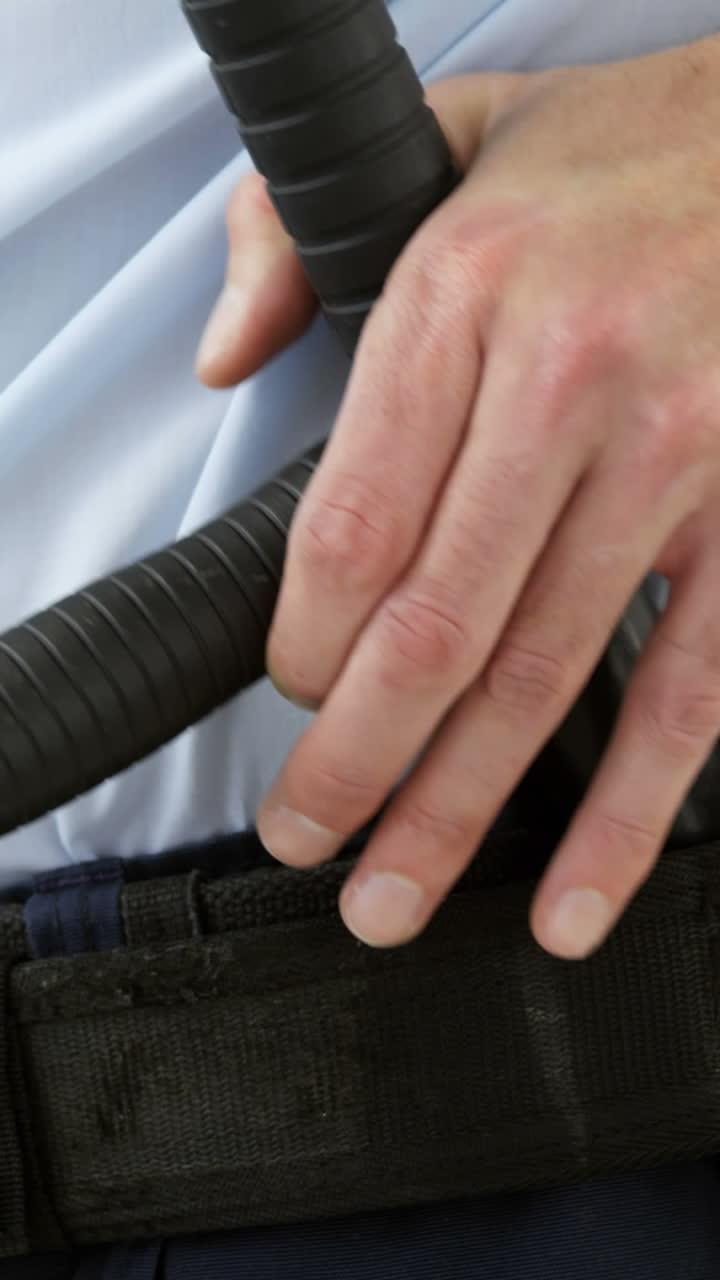 sección media del guardia de seguridad sosteniendo un bastón y un walkie talkie