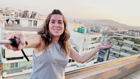 happy woman vlogging on athens rooftop during golden hour