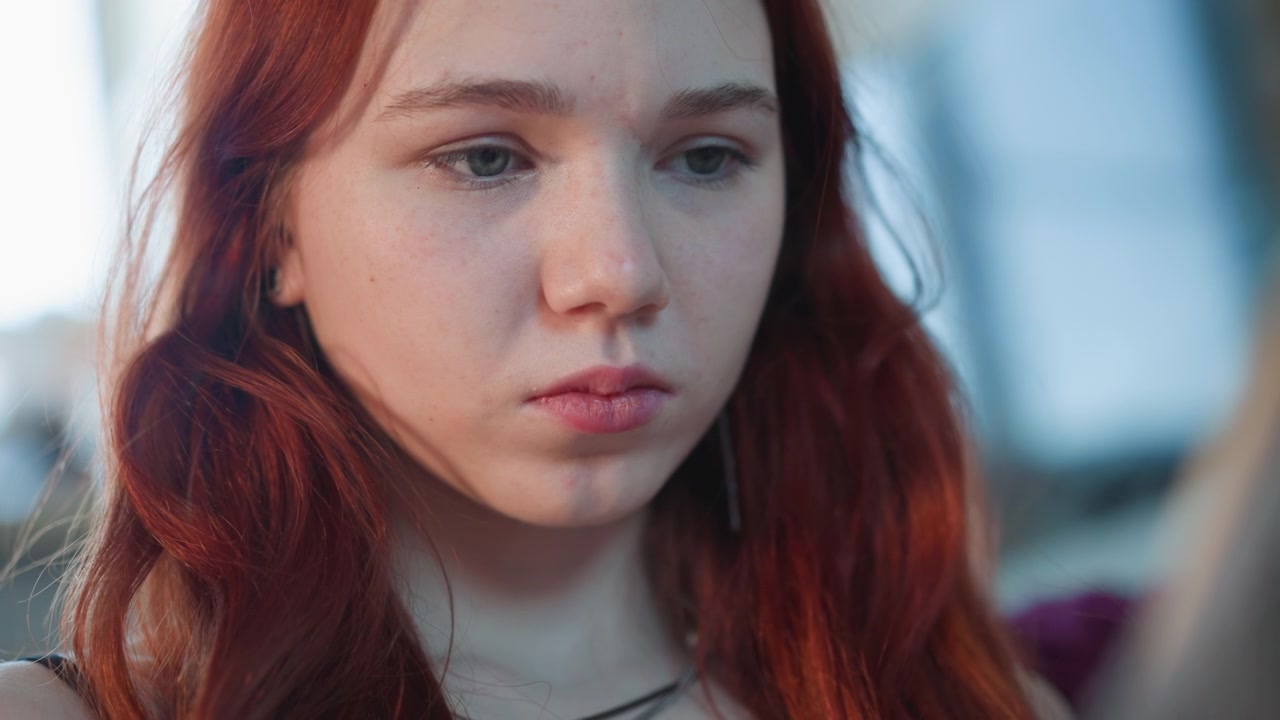 Closeup caucasian redhead reacting to prophecy and message, microexpressions show doubt and quiet sadness, student and seeker digest prediction, soft ambient light on freckled skin, cinematic shallow
