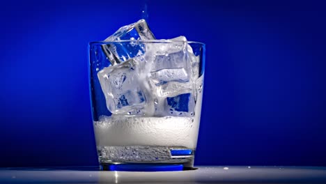 glass of water with ice on a dark blue background