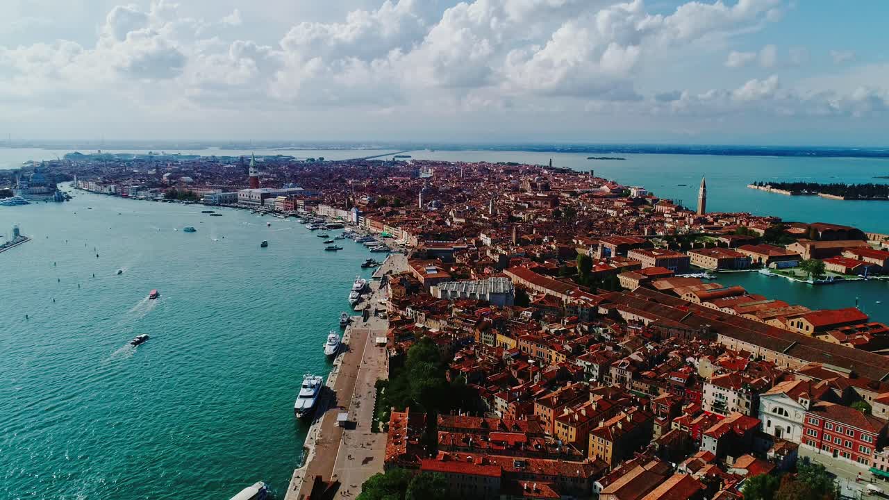 Venice, red rooftops stretch across water as boats weave between narrow canals