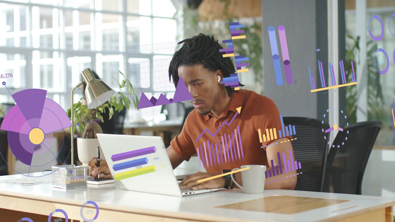 Man typing and writing at desk, incoming data feeding animated charts expanding for data analysis
