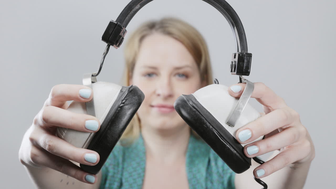 cool female dancer with changing retro headphones to listen to music